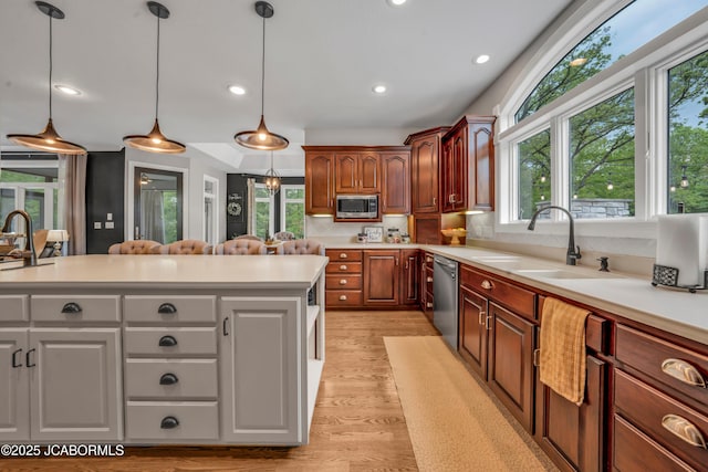 1503 State Highway Z, Centertown, MO 65023 - kitchen featuring a sink, stainless steel appliances, light countertops, light wood-style flooring, and hanging light fixtures