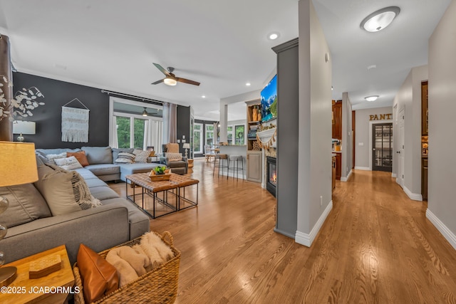 1503 State Highway Z, Centertown, MO 65023 - living room featuring ceiling fan, light wood-style flooring, baseboards, and a glass covered fireplace