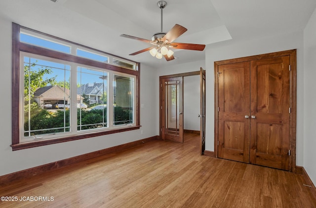 5004 Bates Creek Ct, Columbia, MO 65201 - unfurnished bedroom with light wood-style floors, multiple windows, and ceiling fan