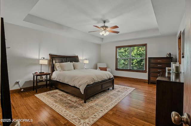 5004 Bates Creek Ct, Columbia, MO 65201 - bedroom featuring a tray ceiling, wood finished floors, and a ceiling fan