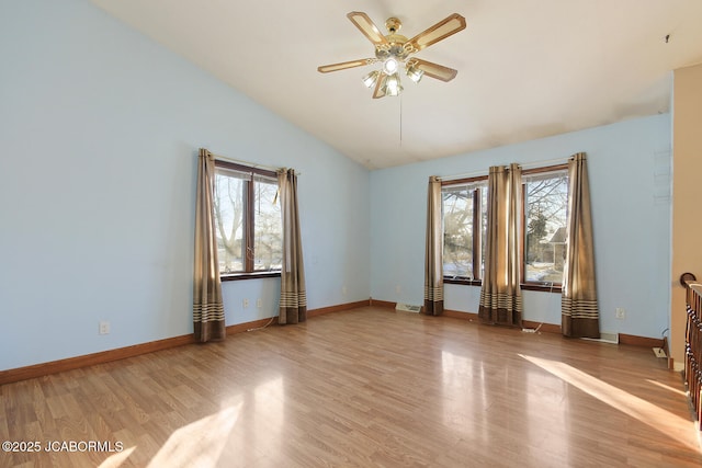 empty room with ceiling fan, high vaulted ceiling, a healthy amount of sunlight, and light wood-type flooring