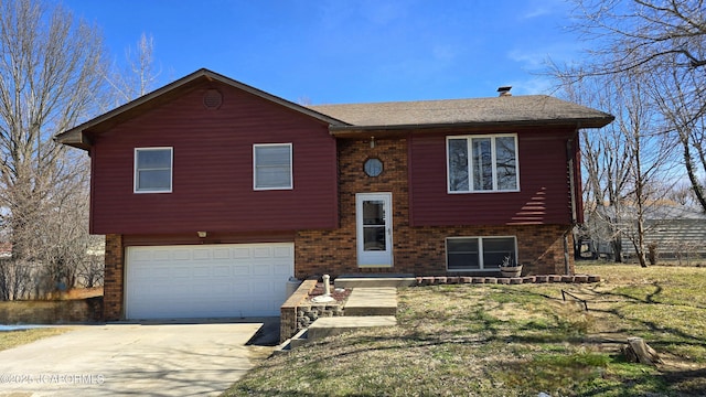 bi-level home with driveway, an attached garage, and brick siding