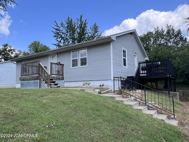 view of front of property with a wooden deck and a front lawn