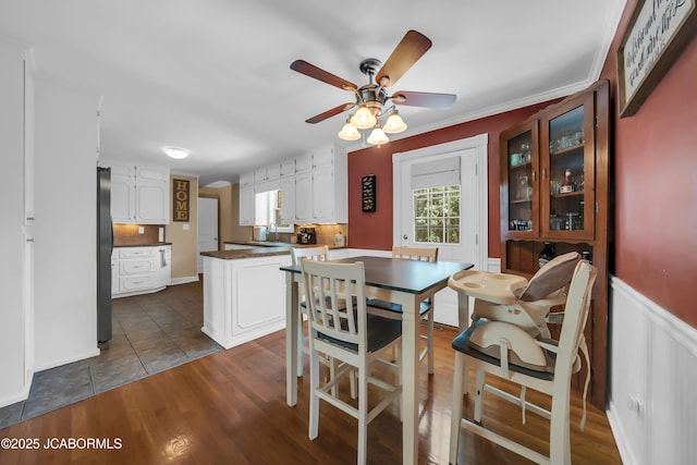 2213 Tanner Bridge Rd, Jefferson City, MO 65101 - dining area featuring a ceiling fan, dark wood-style floors, and wainscoting