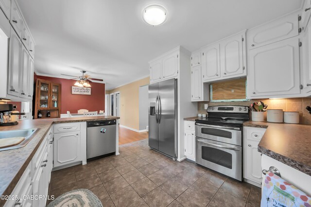 2213 Tanner Bridge Rd, Jefferson City, MO 65101 - kitchen with stainless steel appliances, white cabinetry, a peninsula, decorative backsplash, and ceiling fan