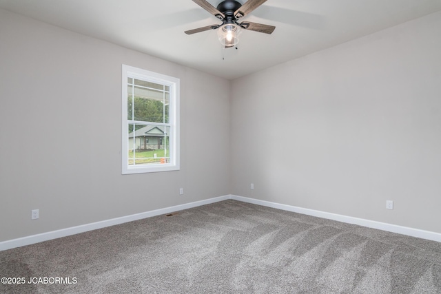 carpeted empty room with a ceiling fan and baseboards
