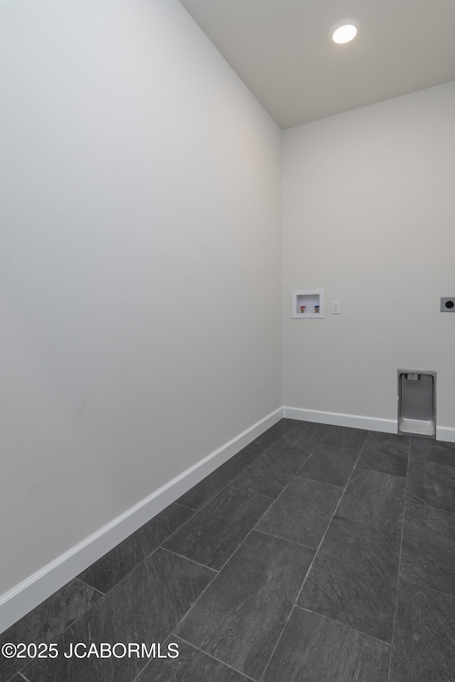 laundry area with dark tile patterned floors, baseboards, laundry area, and washer hookup