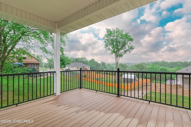 wooden deck featuring a lawn