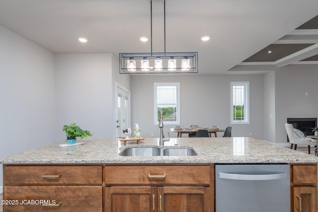 kitchen with light stone countertops, brown cabinets, and dishwasher