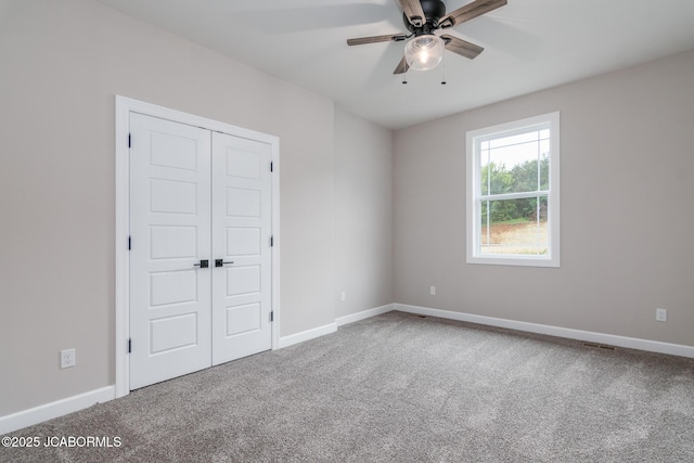 unfurnished bedroom featuring carpet floors, baseboards, and a closet