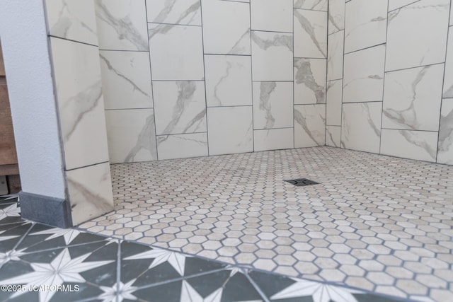 interior details featuring tiled shower
