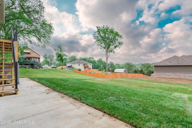 view of yard featuring fence and stairway