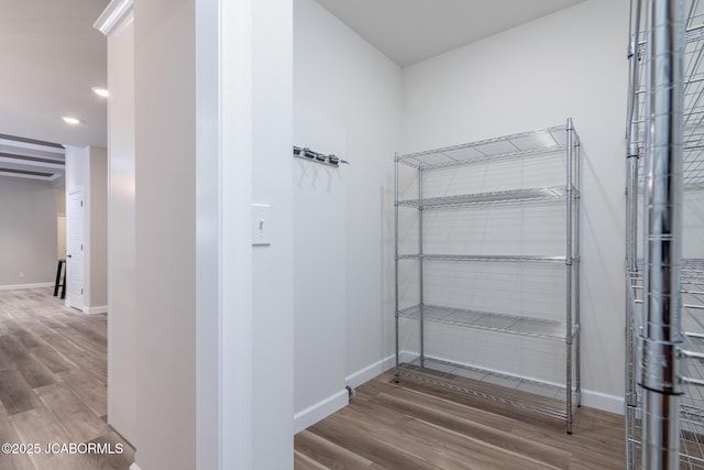 walk in closet with wood finished floors