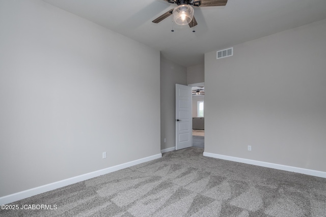 spare room with carpet flooring, a ceiling fan, baseboards, and visible vents