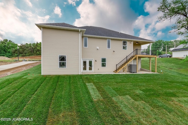 rear view of property with cooling unit, french doors, stairway, and a yard