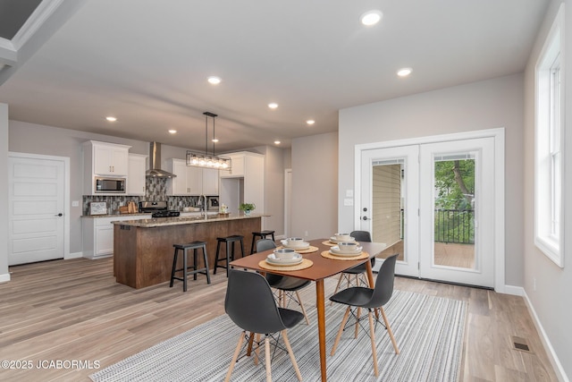 dining area with baseboards, light wood-style flooring, visible vents, and recessed lighting