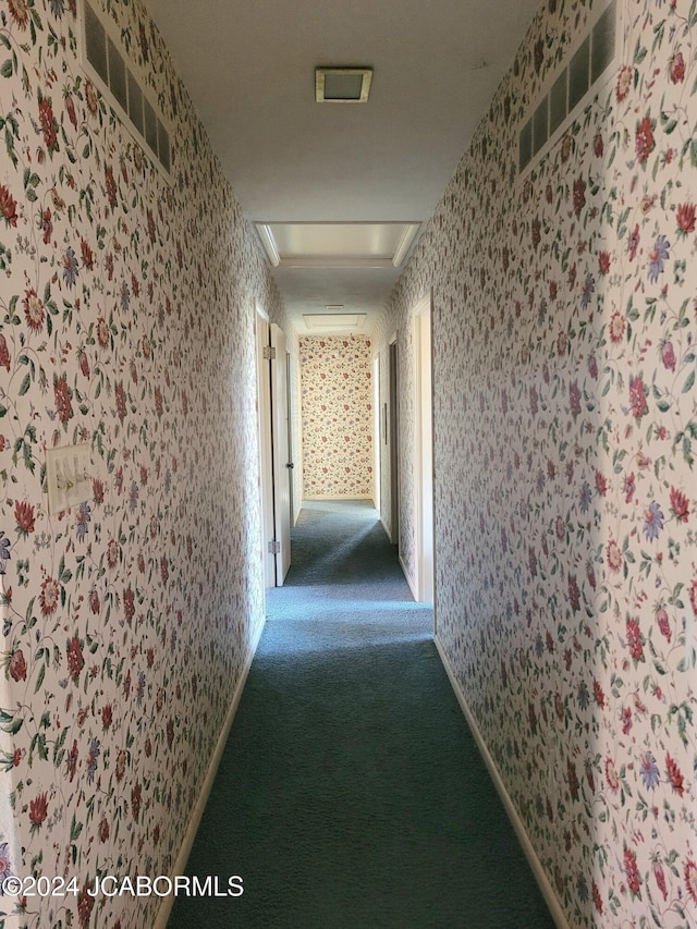 hall with dark colored carpet