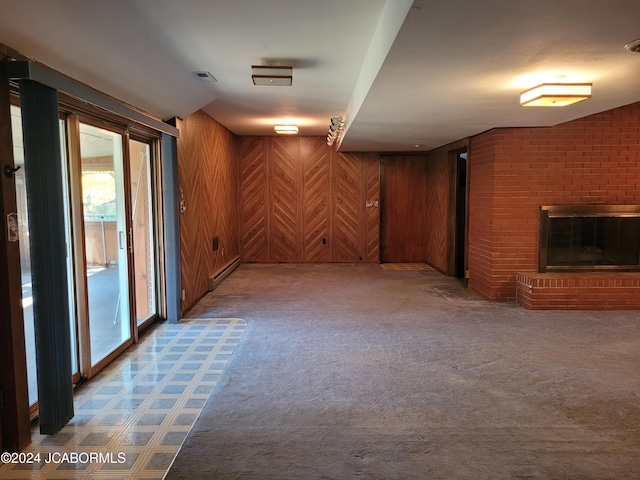 basement featuring a fireplace, light carpet, a baseboard heating unit, and wood walls