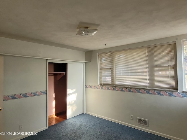 unfurnished bedroom with carpet flooring and a closet