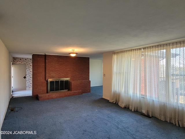 unfurnished living room featuring carpet floors and a brick fireplace