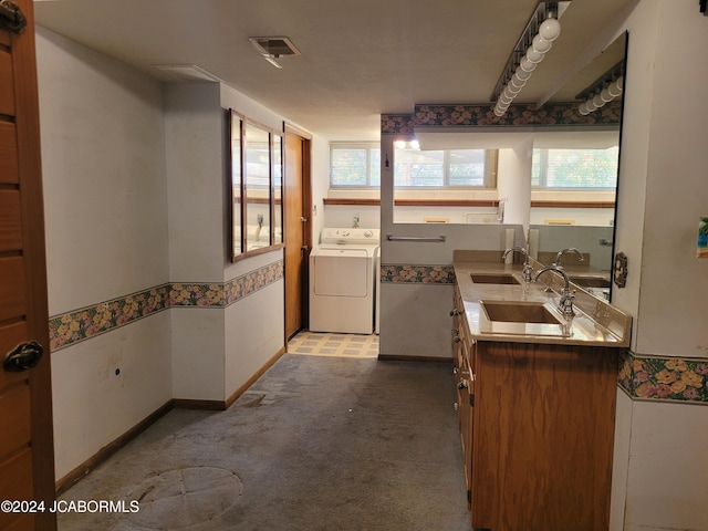 interior space featuring washer / clothes dryer, plenty of natural light, and dual sinks