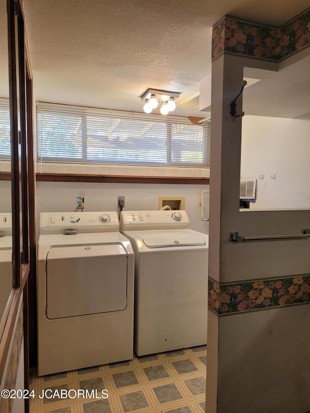 washroom featuring washing machine and clothes dryer and a textured ceiling