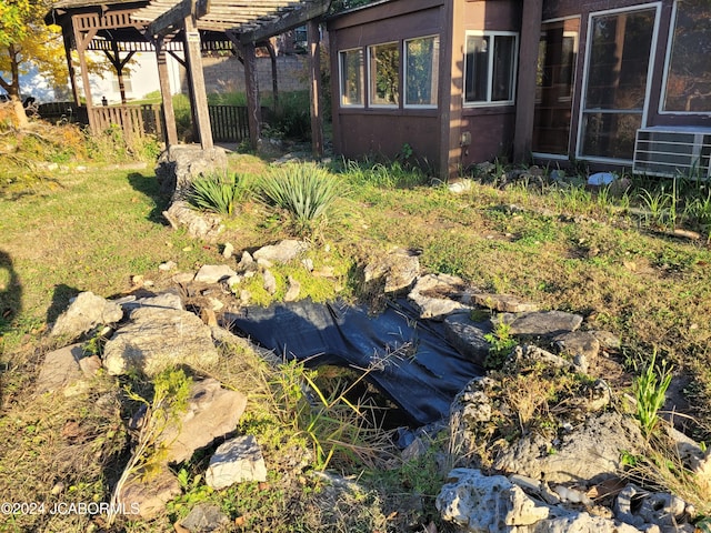 view of yard featuring a pergola and central air condition unit