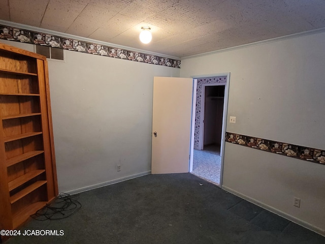 unfurnished room featuring crown molding, a textured ceiling, and dark colored carpet