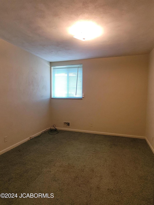 empty room with dark colored carpet