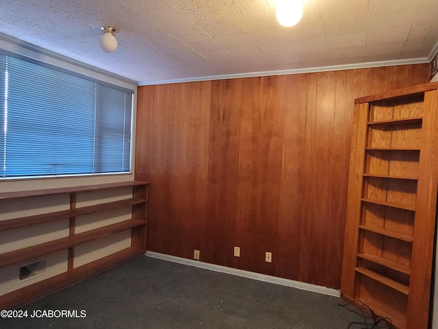 unfurnished room with crown molding and wooden walls