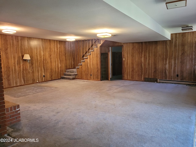 basement featuring wood walls, carpet, and a baseboard heating unit