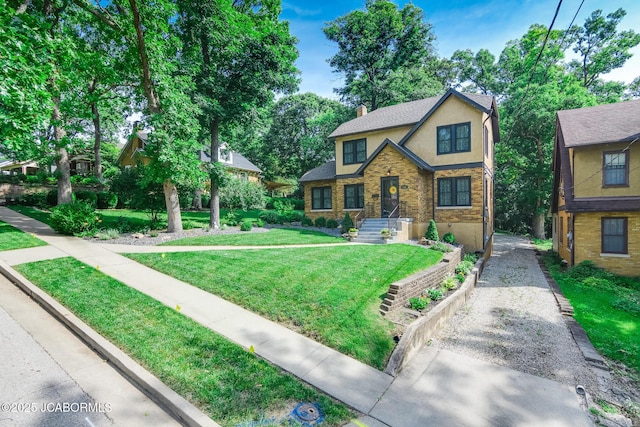 1311 Elmerine Ave, Jefferson City, MO 65101 - tudor house featuring stucco siding, a chimney, a front lawn, and driveway