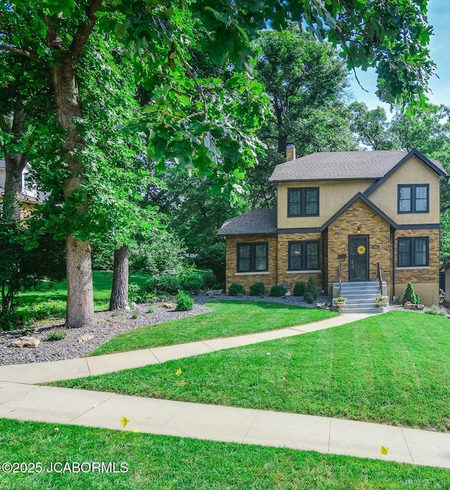 1311 Elmerine Ave, Jefferson City, MO 65101 - view of front of house with stucco siding, a chimney, and a front lawn
