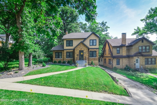 1311 Elmerine Ave, Jefferson City, MO 65101 - tudor home with stucco siding, a chimney, a front lawn, and stone siding
