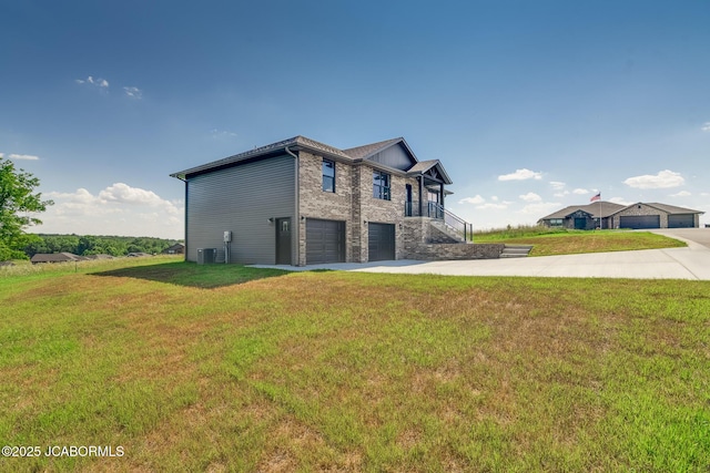 5705 Summerfield Ct, Jefferson City, MO 65109 - view of property exterior featuring a garage, concrete driveway, a lawn, and stone siding