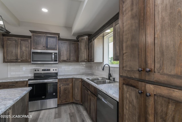 5705 Summerfield Ct, Jefferson City, MO 65109 - kitchen featuring stainless steel appliances, light wood finished floors, dark brown cabinets, decorative backsplash, and light countertops