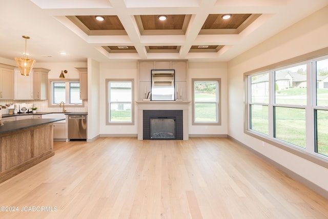 unfurnished living room with sink, coffered ceiling, beamed ceiling, light hardwood / wood-style floors, and a fireplace