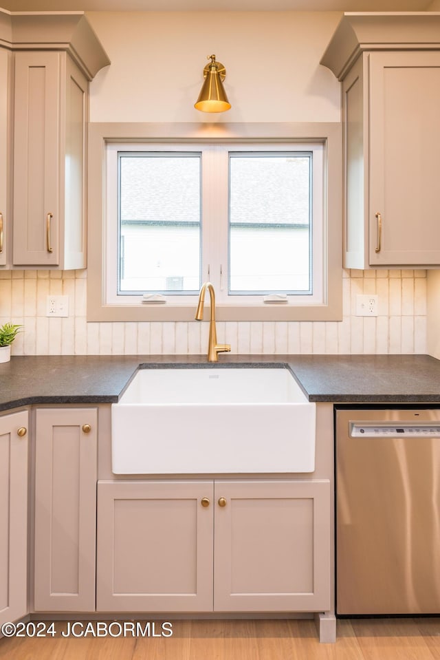 kitchen featuring gray cabinetry, decorative backsplash, sink, and stainless steel dishwasher