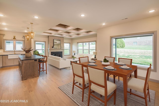 5607 Birch Creek Ln, Jefferson City, MO 65101 - dining area with recessed lighting, light wood finished floors, healthy amount of natural light, coffered ceiling, and a glass covered fireplace