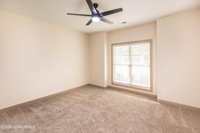 empty room with ceiling fan and light colored carpet