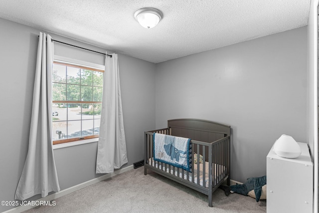 5501 S Brooks Dr, Jefferson City, MO 65109 - bedroom featuring carpet flooring, a textured ceiling, and a crib
