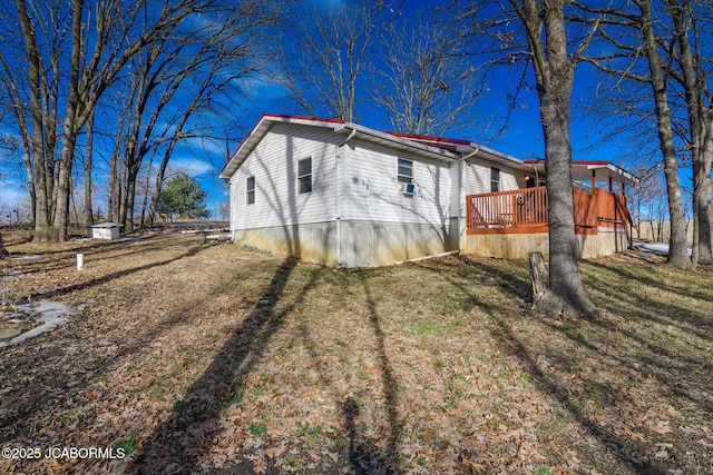 view of property exterior with a yard and a deck