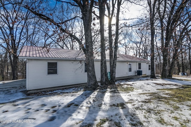 snow covered property with central AC unit