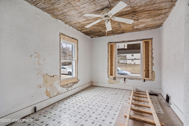 empty room featuring light floors, wooden ceiling, and a ceiling fan