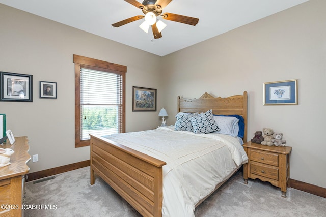 bedroom with visible vents, baseboards, light colored carpet, and a ceiling fan