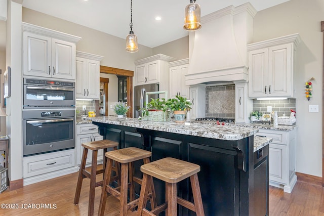 kitchen featuring light wood-style flooring, a breakfast bar area, premium range hood, and stainless steel appliances