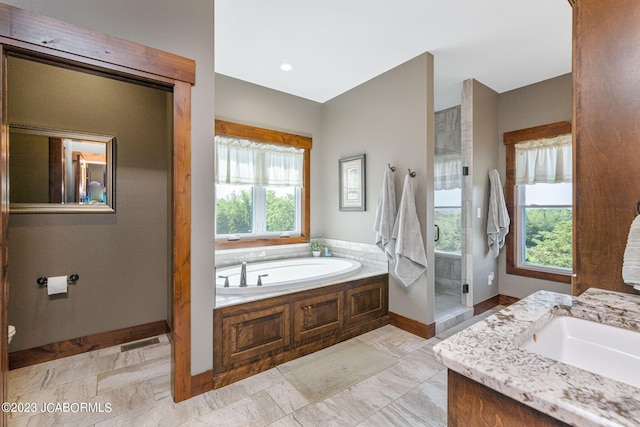 full bathroom featuring visible vents, a shower stall, baseboards, a bath, and vanity