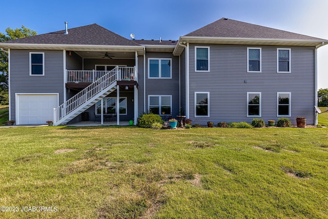 rear view of house featuring stairway, a yard, a ceiling fan, and an attached garage