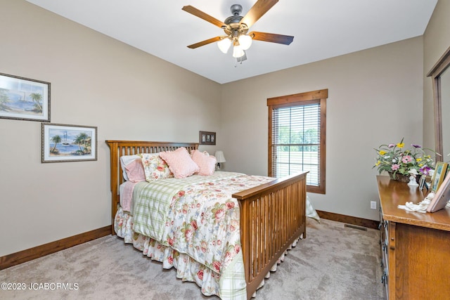 bedroom with light colored carpet, baseboards, and ceiling fan