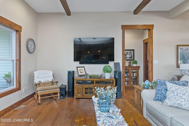 living room with baseboards, visible vents, wood-type flooring, and beam ceiling